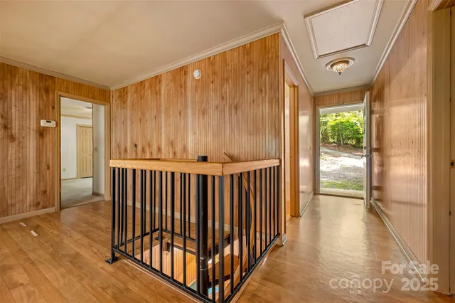 a view of a hallway with wooden floor and door