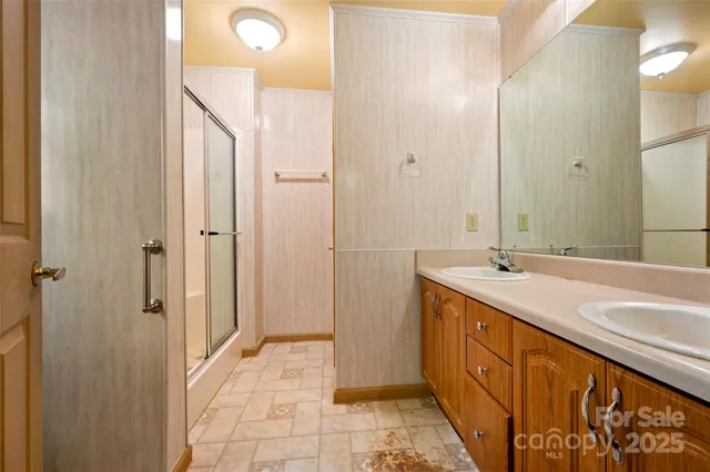 a bathroom with a double vanity sink mirror and shower