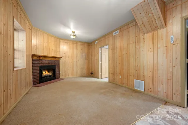 a view of an empty room with a fireplace and a window