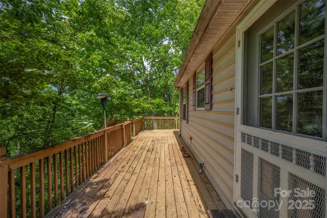 a view of balcony with wooden floor and fence and a potted plant