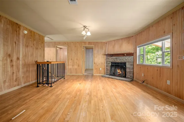 a view of a livingroom with wooden floor a fireplace and window