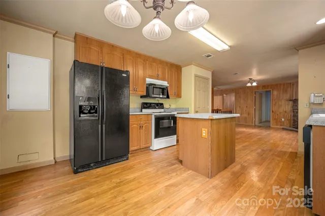 a kitchen with stainless steel appliances granite countertop a refrigerator a stove and a sink
