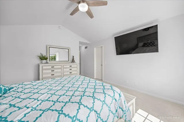 a bedroom with a large bed and a flat tv screen on dresser