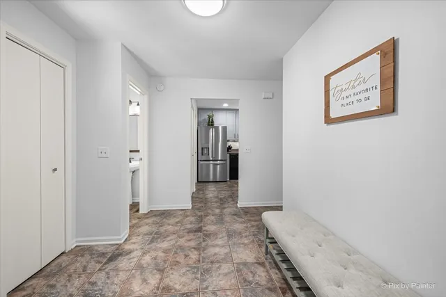 a view of a hallway with wooden floor and a bathroom
