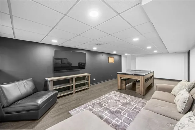 a living room with furniture a flat screen tv and kitchen view