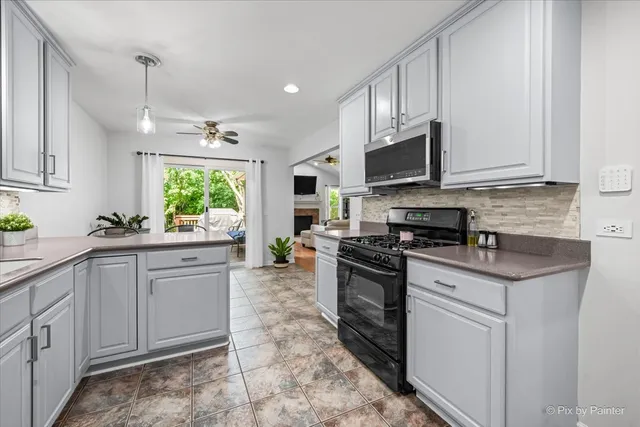 a kitchen with stainless steel appliances granite countertop a stove a sink and a microwave