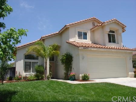 a front view of a house with a garden and plants
