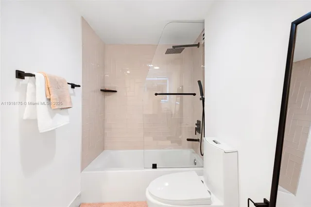 a bathroom with a bathtub shower and toilet