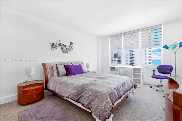 a bedroom with a bed and large windows
