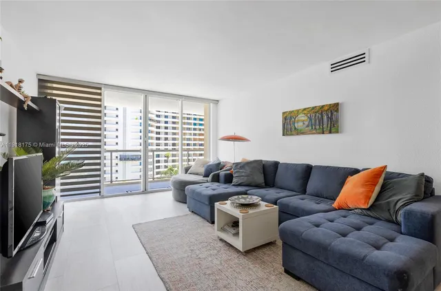 a living room with furniture a flat screen tv and a window