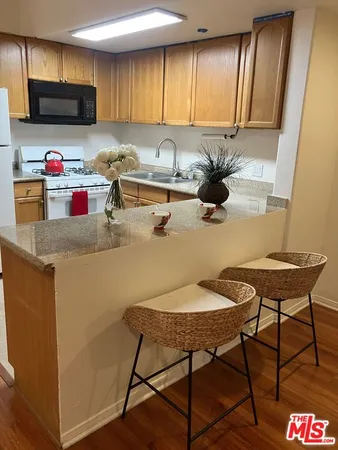 a kitchen with stainless steel appliances wooden cabinets sink and cabinets