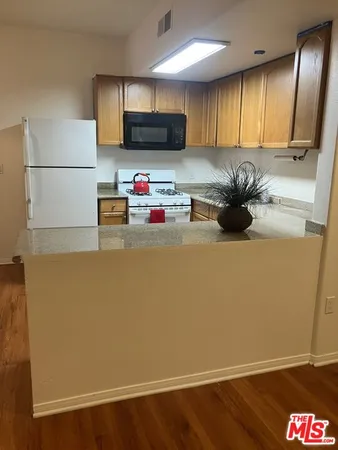 a kitchen with microwave and refrigerator