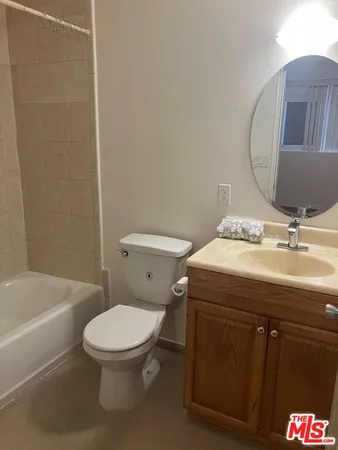 a bathroom with a granite countertop toilet sink and mirror