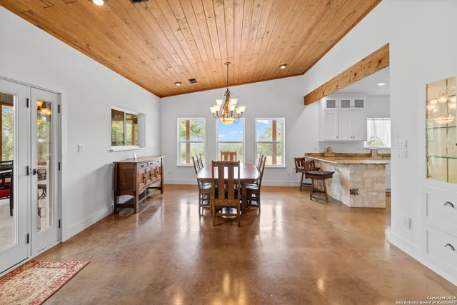 a kitchen with stainless steel appliances granite countertop a stove top oven a sink a refrigerator and white cabinets