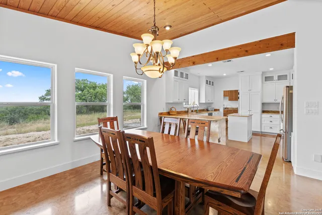 a dining hall with stainless steel appliances granite countertop a sink and a large window