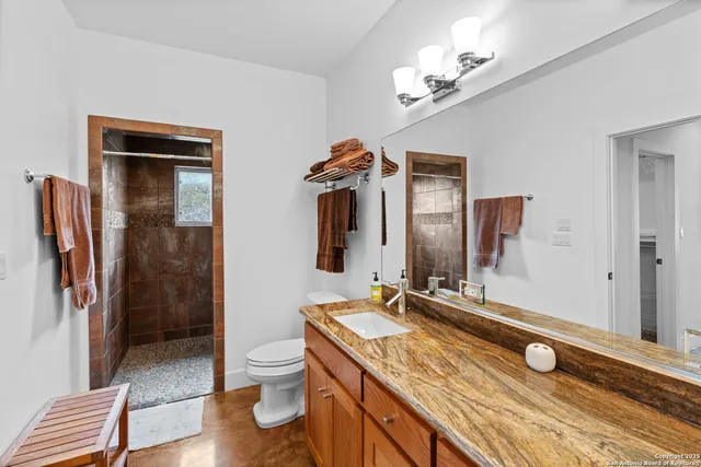 a bathroom with a granite countertop sink toilet and shower