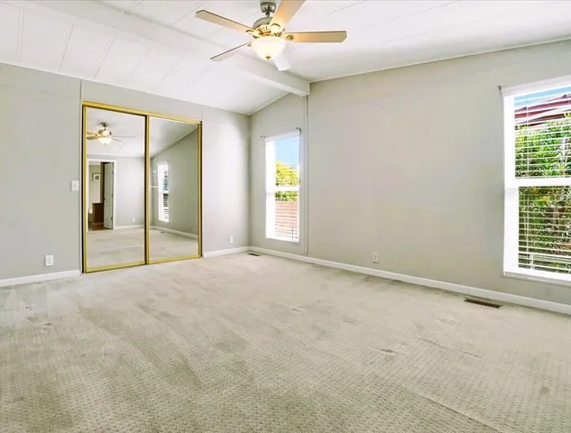 a spacious bathroom with double vanity sink a mirror and a toilet