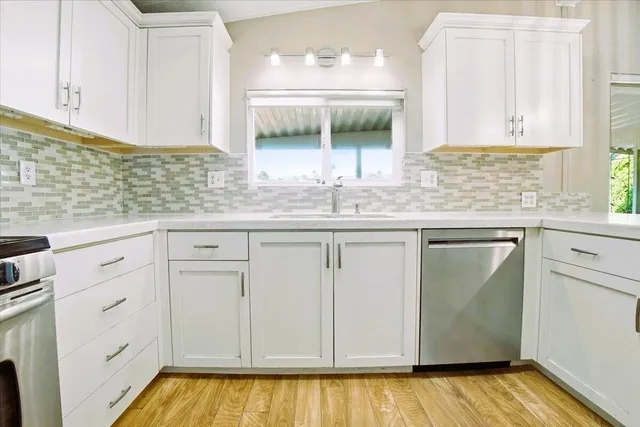a kitchen with white cabinets and sink