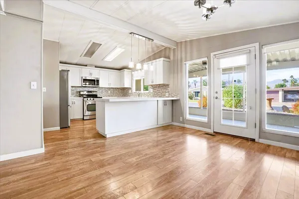 a kitchen with a refrigerator stove and wooden floor