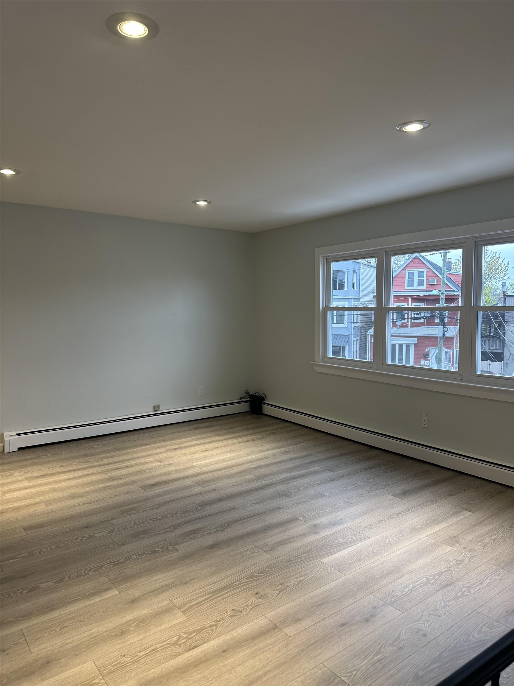 10 West Grand Street, Unit 2 Bayonne, NJ 07002 - Photo 5 of 13 an empty room with wooden floor and windows