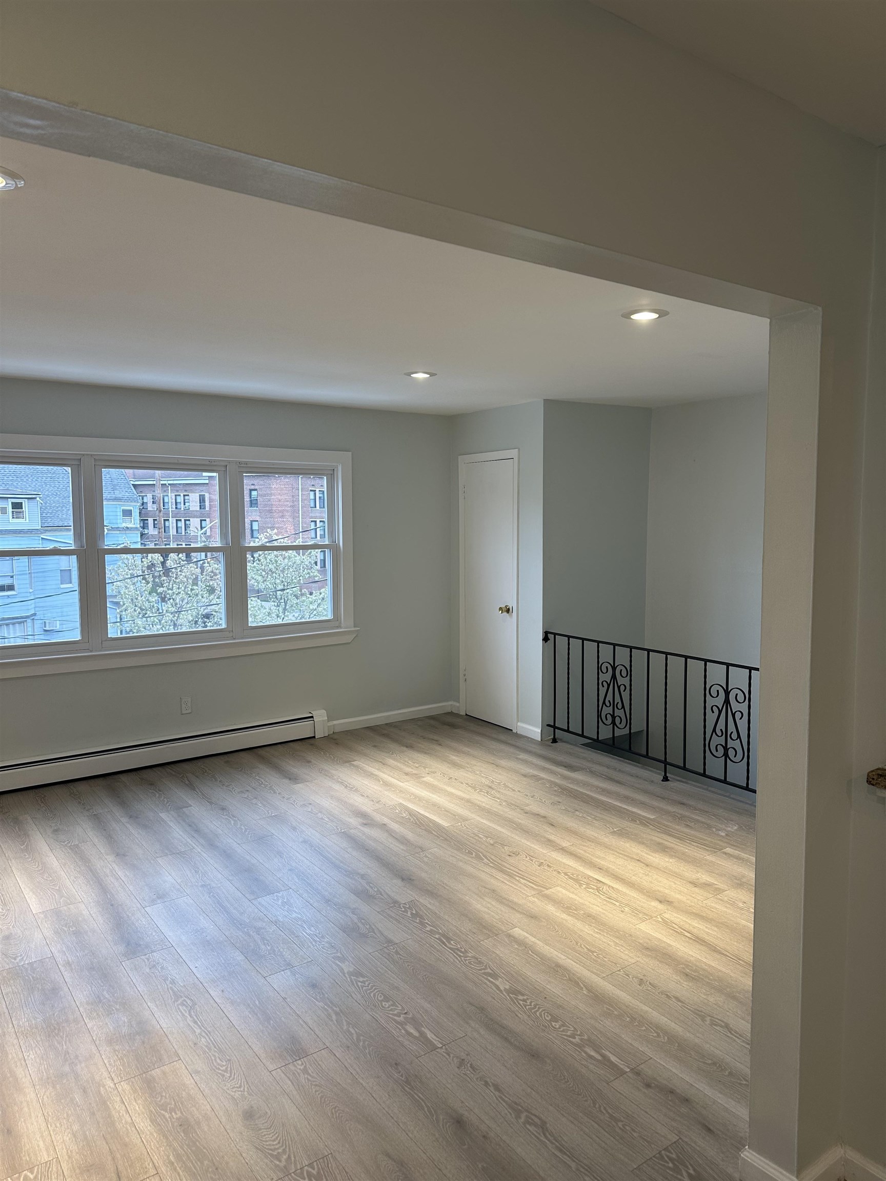 10 West Grand Street, Unit 2 Bayonne, NJ 07002 - Photo 6 of 13 a view of an empty room with wooden floor and a window