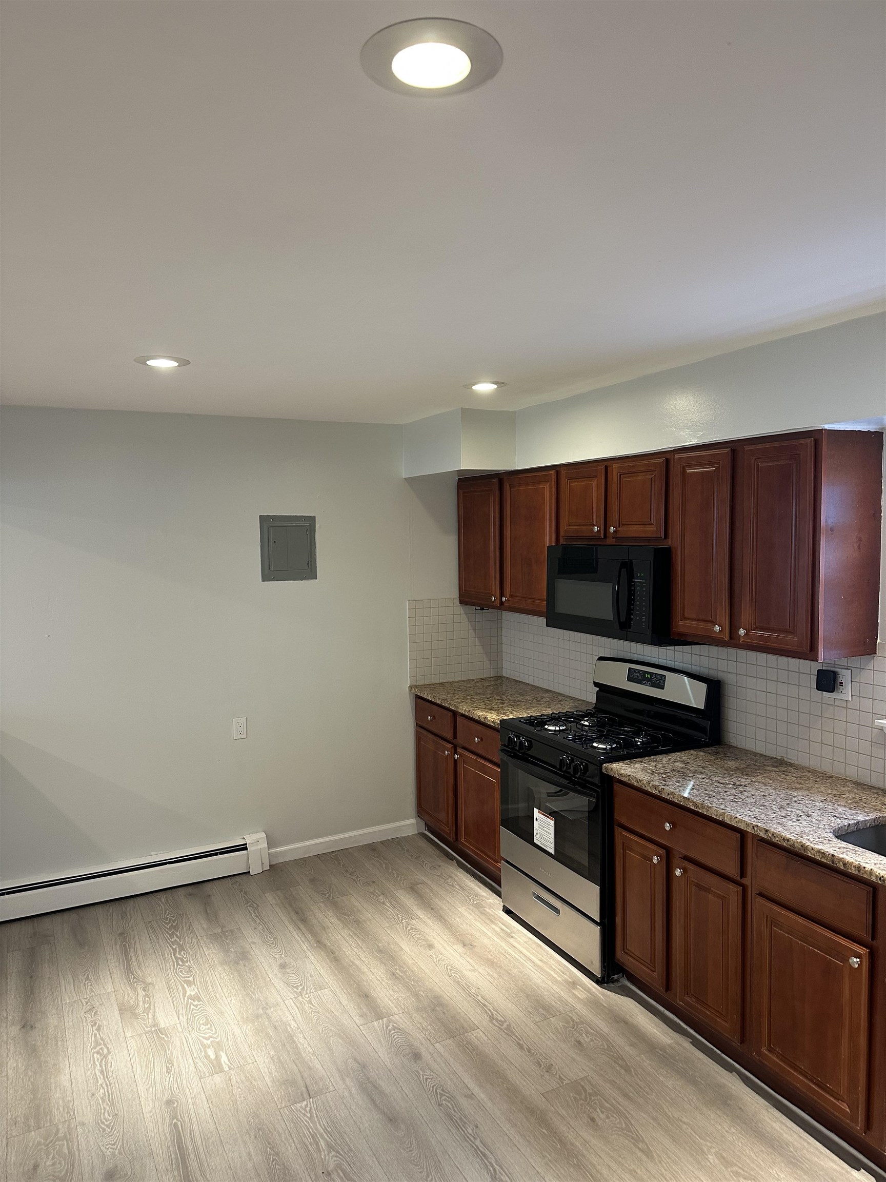 10 West Grand Street, Unit 2 Bayonne, NJ 07002 - Photo 7 of 13 a kitchen with stainless steel appliances granite countertop a stove a sink and a refrigerator
