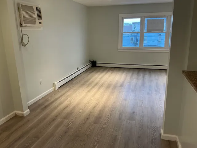 a view of a room with wooden floor and window