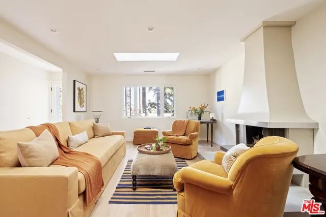 a living room with furniture a fireplace and a large window