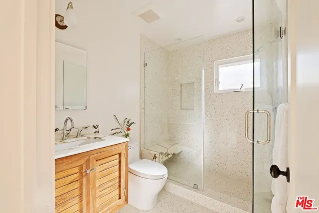 a bathroom with a granite countertop sink toilet and shower