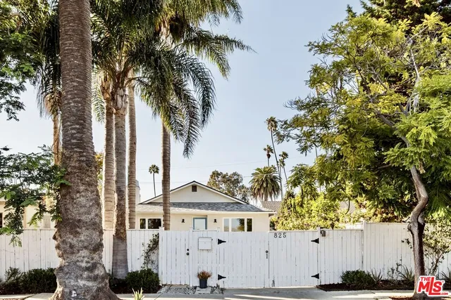 a view of a white house with palm trees