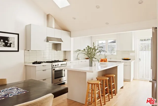 a kitchen with stainless steel appliances a stove a sink and a refrigerator