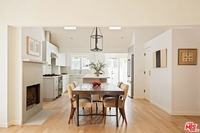 a kitchen with a dining table chairs and refrigerator