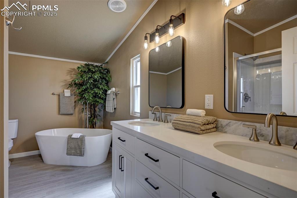 33115 Torrence Road Yoder, CO 80864 - Photo 27 of 50 a bathroom with a granite countertop tub a double vanity sink and mirror