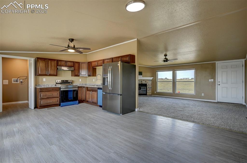 33115 Torrence Road Yoder, CO 80864 - Photo 5 of 50 a kitchen with stainless steel appliances a refrigerator and wooden floor