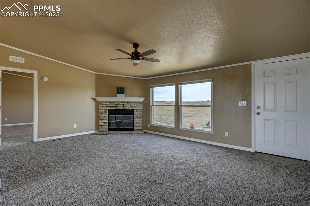 33115 Torrence Road Yoder, CO 80864 - Photo 9 of 50 an empty room with windows and fireplace