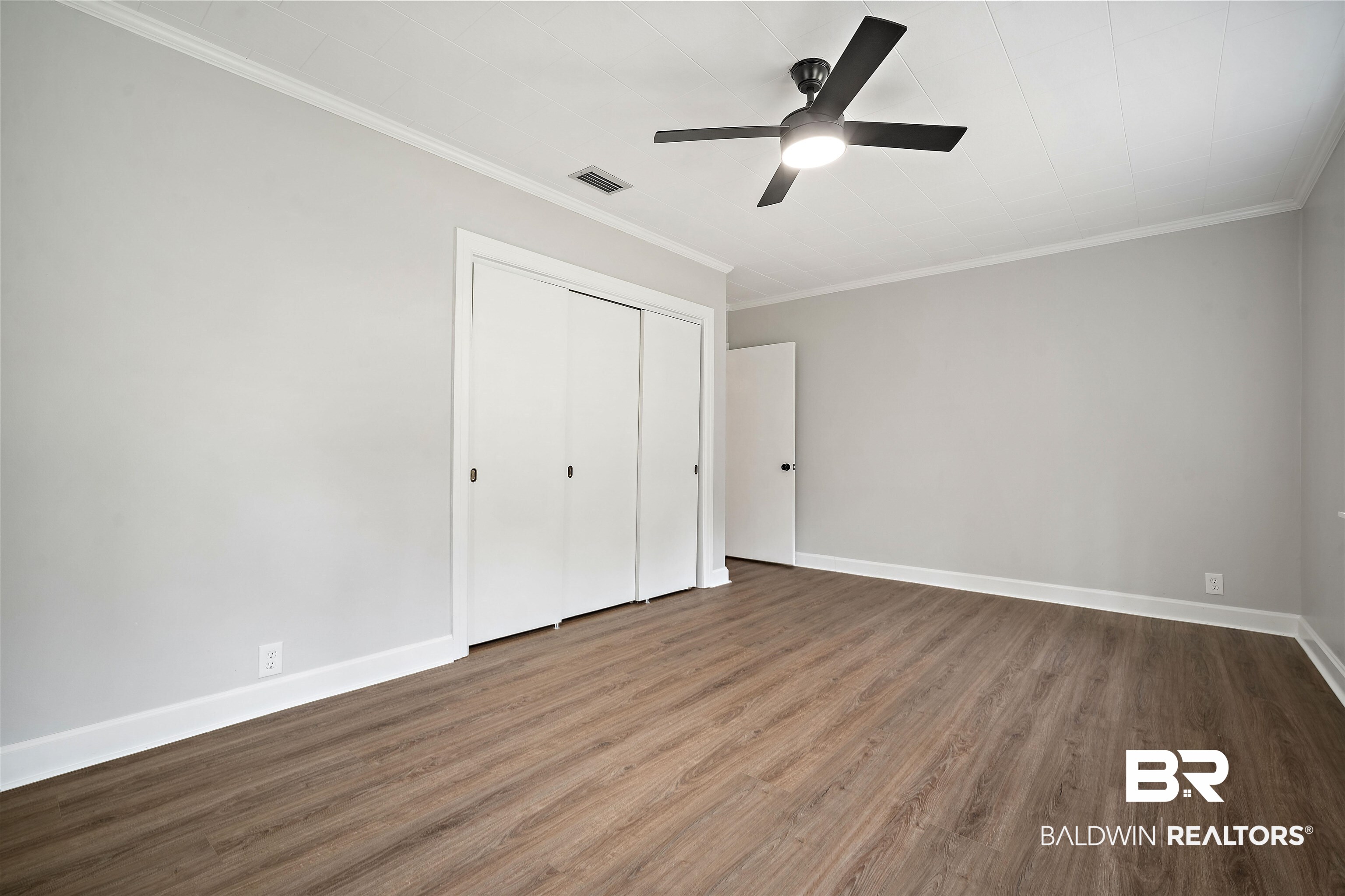 2261 Island Road Mobile, AL 36605 - Photo 15 of 25 Unfurnished bedroom with dark wood finished floors, crown molding, a ceiling fan, and a closet