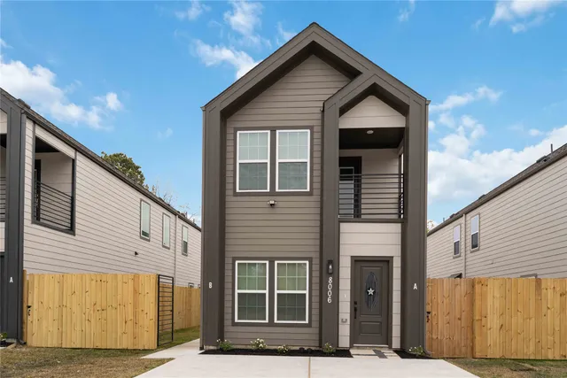 a view of a house with wooden fence