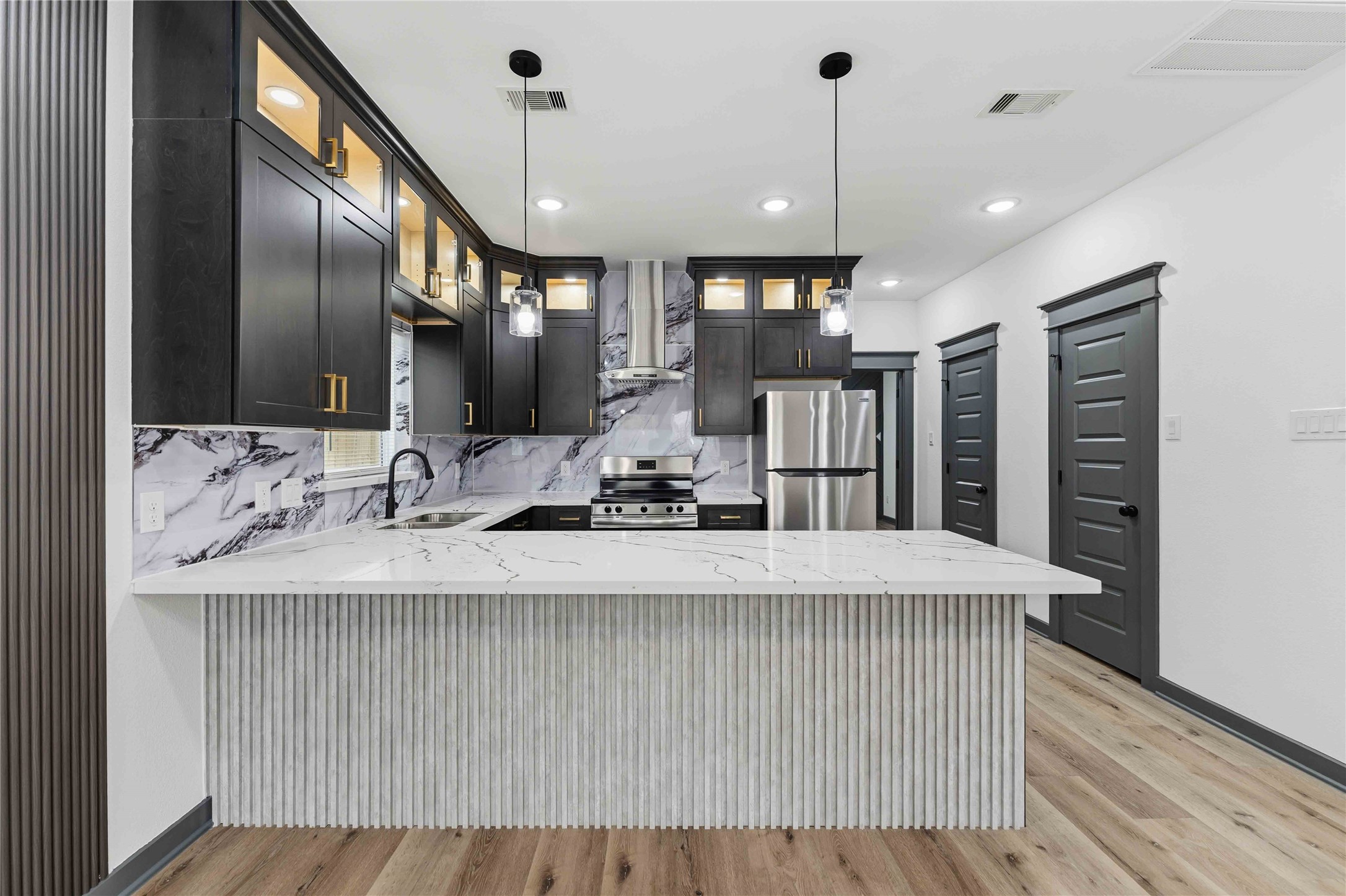 8006 Birmingham Street, Unit A/B Houston, TX 77028 - Photo 5 of 24 a view of a kitchen with kitchen island a sink stainless steel appliances and cabinets