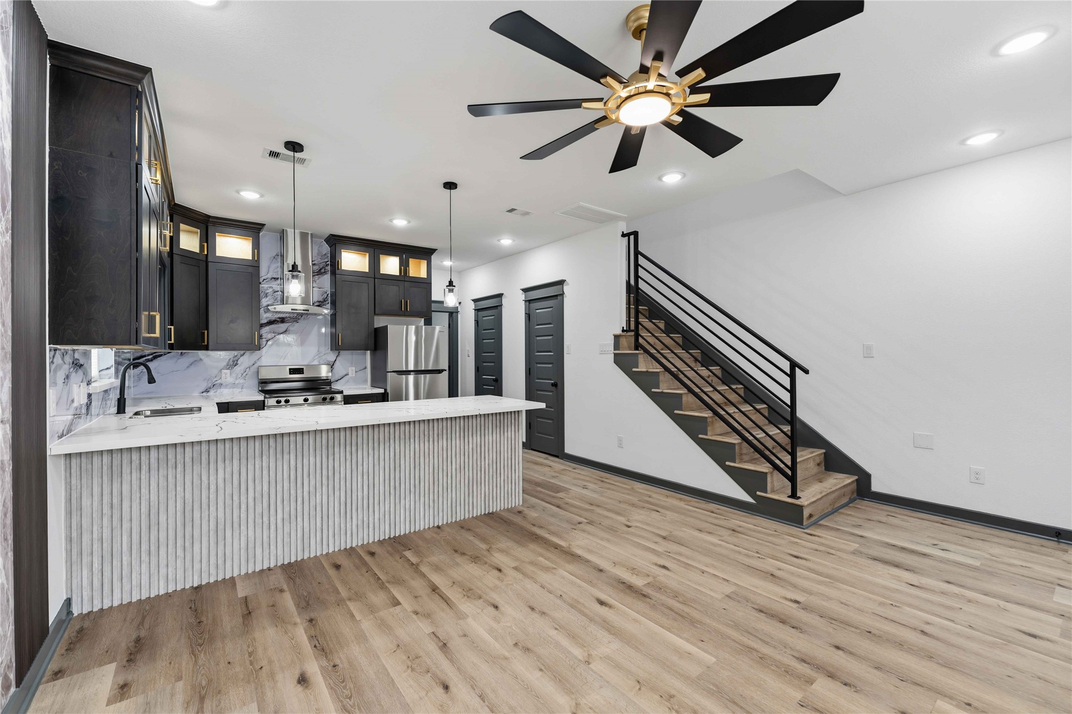 8006 Birmingham Street, Unit A/B Houston, TX 77028 - Photo 6 of 24 a large living room with stainless steel appliances kitchen island a chandelier and fireplace