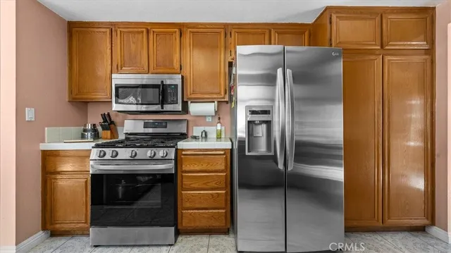 a kitchen with stainless steel appliances granite countertop a refrigerator and a stove