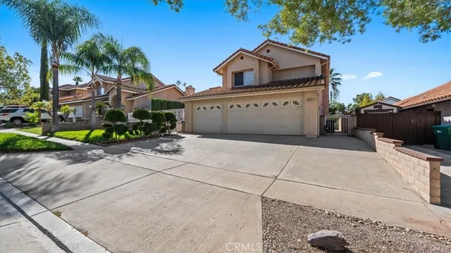 a view of a house with a yard and palm trees