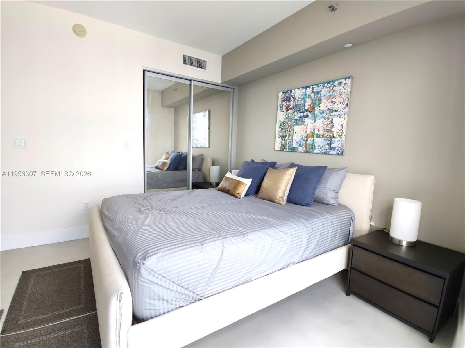 465 Brickell Avenue, Unit 4402 Miami, FL 33131 - Photo 22 of 33 a bedroom with a bed and a lamp with window