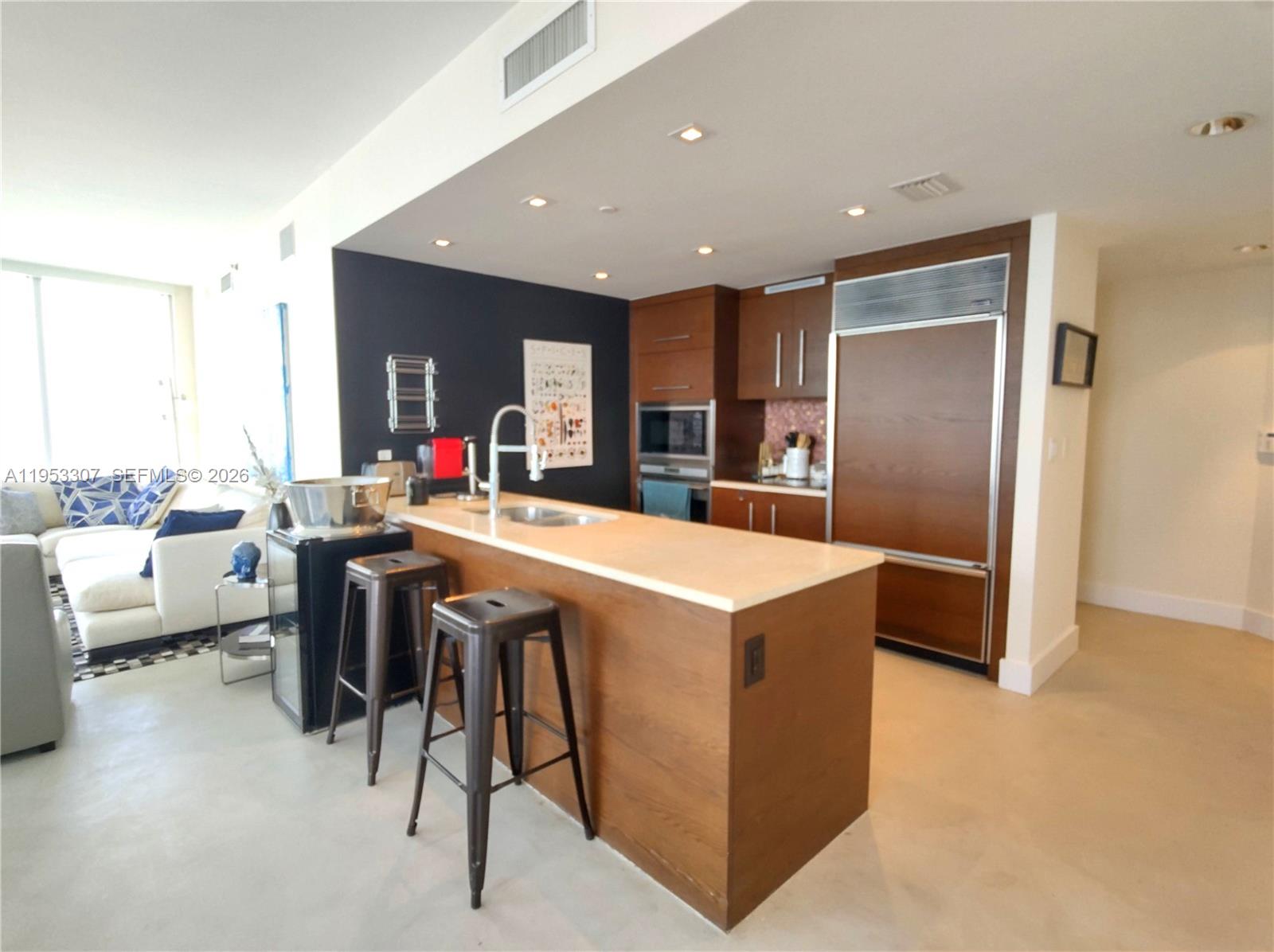 465 Brickell Avenue, Unit 4402 Miami, FL 33131 - Photo 10 of 33 a kitchen with stainless steel appliances kitchen island granite countertop a refrigerator a sink a stove and a oven with wooden floor