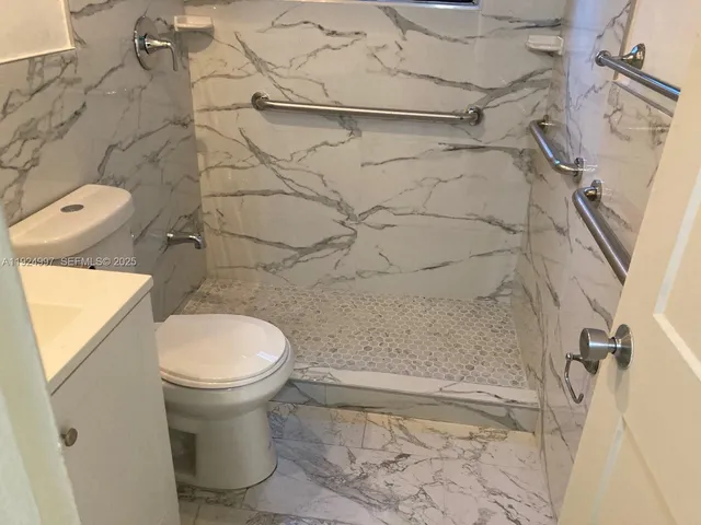 a bathroom with a toilet and a shower
