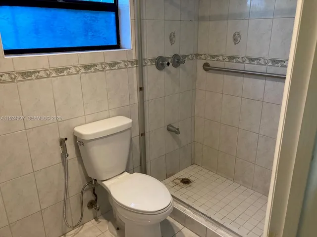 a bathroom with a toilet and a shower