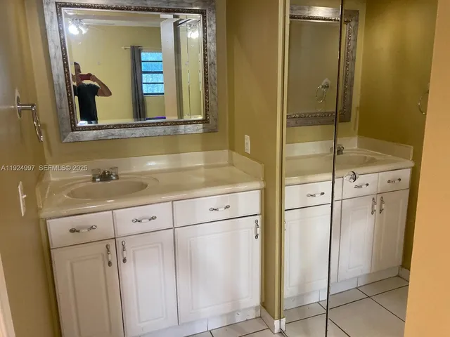 a bathroom with a shower sink and mirror