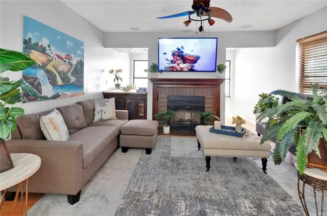 a living room with furniture a fireplace and a potted plant