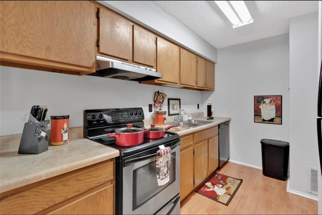 2411 Huntingdon, Unit 2411 Atlanta, GA 30350 - Photo 16 of 45 a kitchen with stainless steel appliances granite countertop a sink stove and cabinets