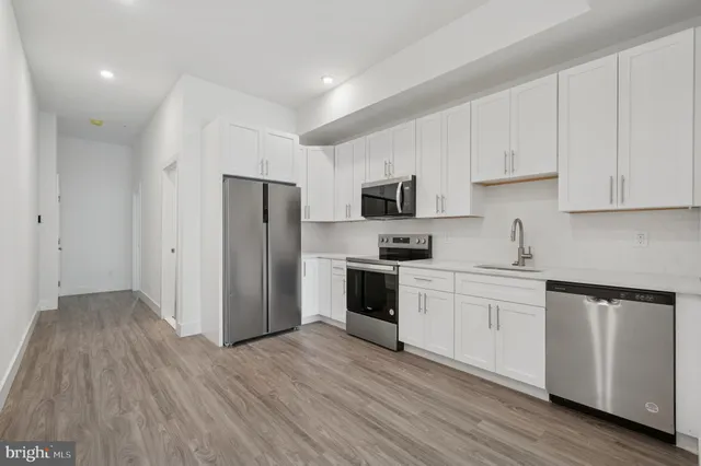 a kitchen with a refrigerator stove and white cabinets
