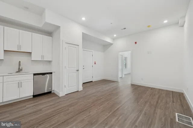 a view of a kitchen with wooden floor and a sink